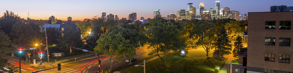 Twilight view of city street with skyline in background